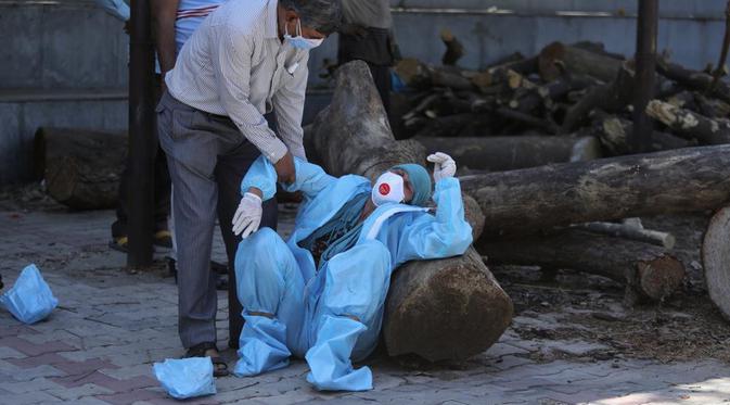 Seorang anggota keluarga pasien COVID-19 yang meninggal di Jammu, India, Minggu (25/4). Dok: AP Photo/Channi Anand
