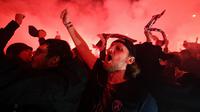 Para suporter Paris Saint-Germain (PSG) merayakan kemenangan PSG atas Borussia Dortmund di depan Stadion Parc des Princes, Paris, Rabu (11/3/2020). Kemenangan tersebut mengantarkan PSG ke perempat final Liga Champions. (AFP/Franck Fife)