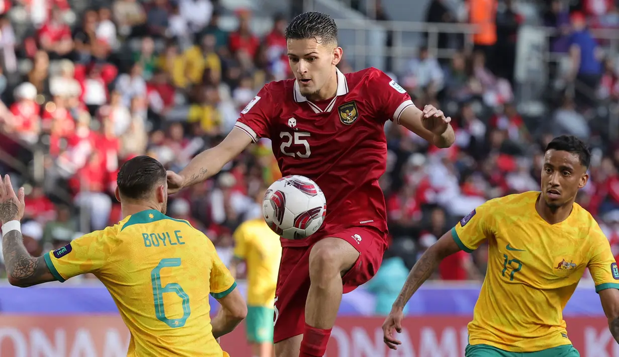 Pemain Timnas Indonesia, Justin Hubner mengontrol bola dibayangi sejumlah pemain Australia saat laga 16 besar Piala Asia 2023 yang berlangsung di assim bin Hamad Stadium, Doha, Qatar, Minggu (28/01/2024). (AFP/Giuseppe Cacace)