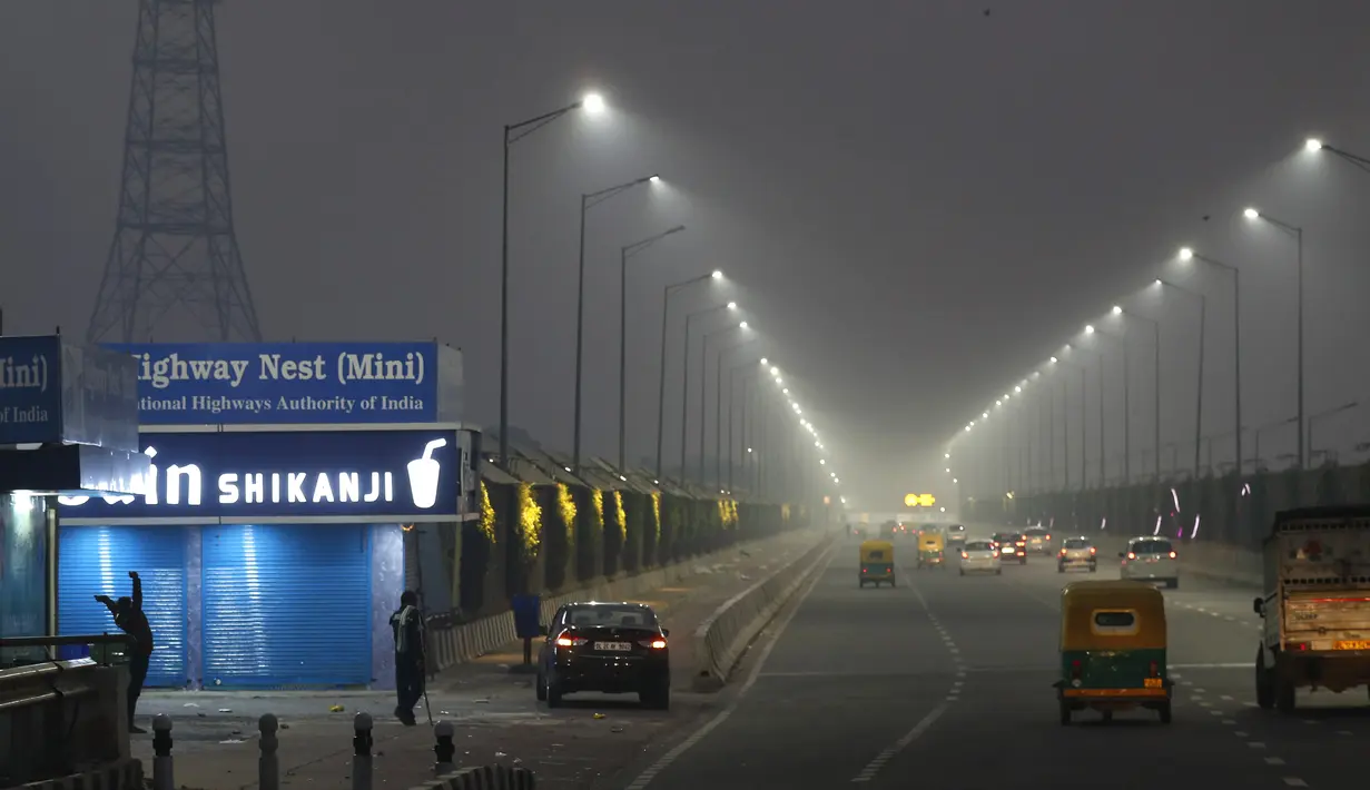 Petugas berjaga pada pagi hari tengah-tengah kabut tipis di New Delhi, India India (28/10/2019). Kualitas udara buruk di New Delhi pada pagi hari tersebut terjadi setelah festival Hindu Diwali. (AP Photo/Manish Swarup)