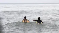 Di pantai pesisir Karang Bolong, Banten, beberapa anak nelayan mencoba keberanian dengan bermain selancar (Liputan6.com/Faizal Fanani) 