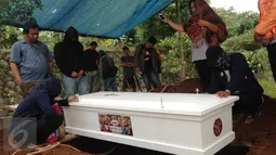 Peti jenazah Ramlan Butarbutar saat ingin diturunkan di TPU Kalimulya III, Depok, Jawa Barat, Jumat, (30/12). Ramlan merupakan sopir angkot di Pulo Gadung dan telah memiliki tiga anak. (Liputan6.com/Ady Anugrahadi)