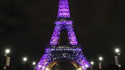 Pengunjung berjalan di sekitar Menara Eiffel yang diterangi dengan huruf bertuliskan '300 juta terima kasih' di Paris, Kamis (28/9). Menara yang mulai dibuka pada 1889 itu merayakan 300 juta pengunjung dengan sejumlah pagelaran musik. (LUDOVIC MARIN/AFP)