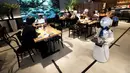 Robot humanoid mengantarkan minuman kepada pelanggan di Dawn Cafe, Tokyo, Jepang, 17 Agustus 2021. Peluncuran kafe ini bersamaan dengan Paralimpiade yang akan dibuka pada 24 Agustus. (Behrouz MEHRI/AFP)