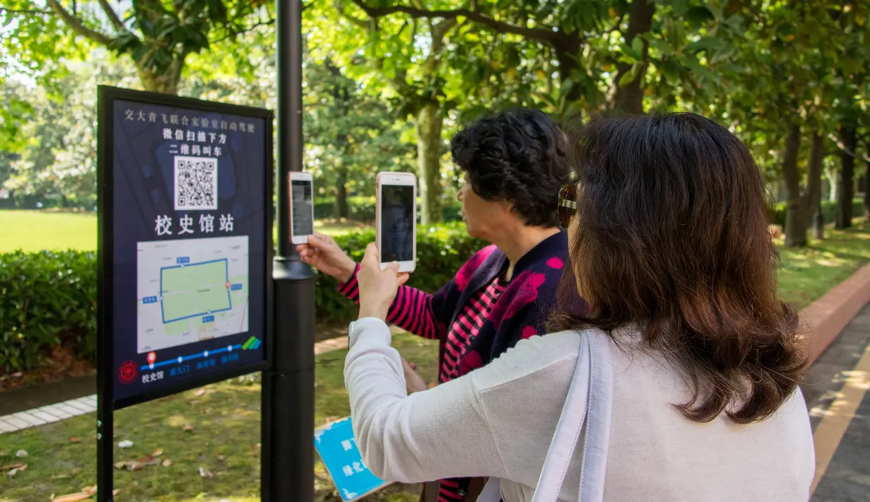 Calon penumpang memindai kode QR untuk memesan sebelum menaiki minibus tanpa awak di Shanghai Jiao Tong University di Shanghai, China (8/5). Bus ini sedang dalam tahap operasi uji coba. (AFP Photo/China Out)