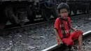 Seorang bocah laki-laki tampak duduk di bantalan rel kawasan Jakarta Barat, Jumat (20/06/14). (Liputan6.com/Faisal R Syam)