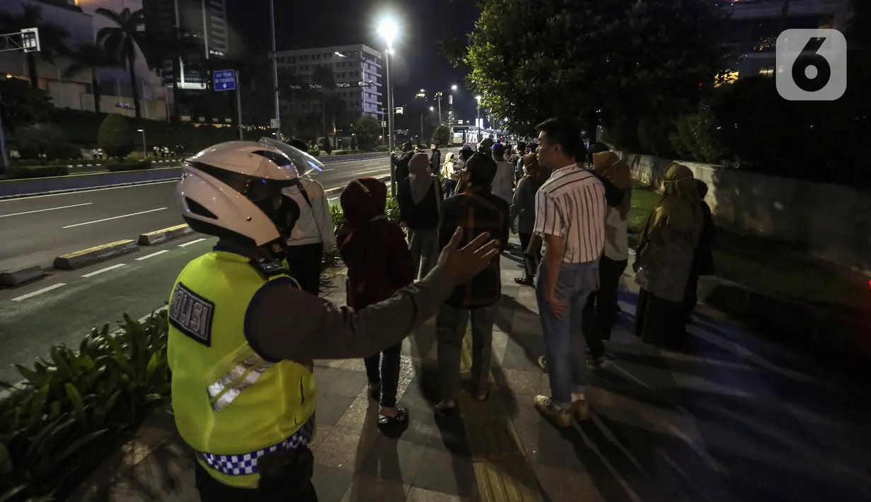 Polisi membubarkan kerumunan warga saat perayaan malam Tahun Baru di Jakarta, Jumat (31/12/2021). Polda Metro Jaya melakukan pengendalian mobilitas Crowd Free Night (malam bebas keramaian) dengan membubarkan warga yang nekat keluar rumah dan tidak mematuhi aturan. (Liputan6.com/Johan Tallo)
