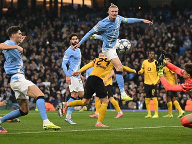 Kiper Dortmund asal Swiss, Gregor Kobel (kanan) menepis tembakan pemain depan Manchester City asal Norwegia, Erling Haaland, dalam pertandingan lanjutan fase liga Liga Champions 2025/2026 antara Manchester City dan Borussia Dortmund di Stadion Etihad, Manchester, Inggris barat laut, pada 5 November 2025 waktu setempat atau Kamis (6/11) dini hari WIB. (Oli SCARFF/AFP)