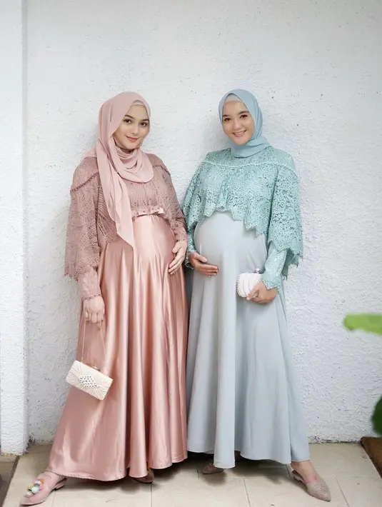 Hamil bersama, keduanya nampak mengenakan dress satin ditambah bordiran di bagian atas. Yang berbeda hanya warna pakaiannya saja. Credit: Instagram (@ericaputrii)