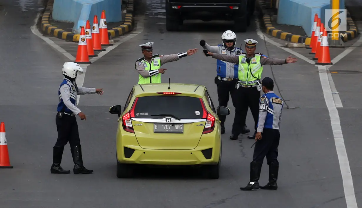 Polisi dan petugas Dishub memberi arahan kepada pengendara mobil di depan Gerbang Tol Bekasi Barat 1, Bekasi, Jawa Barat, Senin (12/3). (Liputan6.com/Arya Manggala)