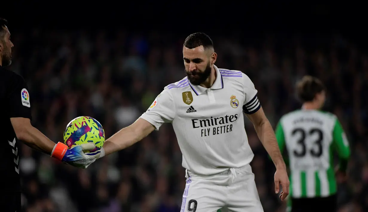 Penyerang Real Madrid, Karim Benzema mengambil bola saat bertanding melawan Real Betis pada pertandingan La Liga Spanyol di stadion Benito Villamarin di Seville, Senin (6/3/2023). Di laga ini gol Benzema di menit 12 sempat dianulir VAR dan Los Blancos hanya mampu bermain imbang tanpa gol dengan Real Betis. (AFP/CRISTINA QUICLER)