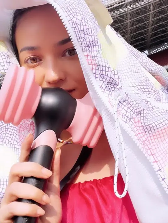 Enzy Storia tampak mengenakan top warna fuschia dengan jaket berwarna putih. @enzystoria.