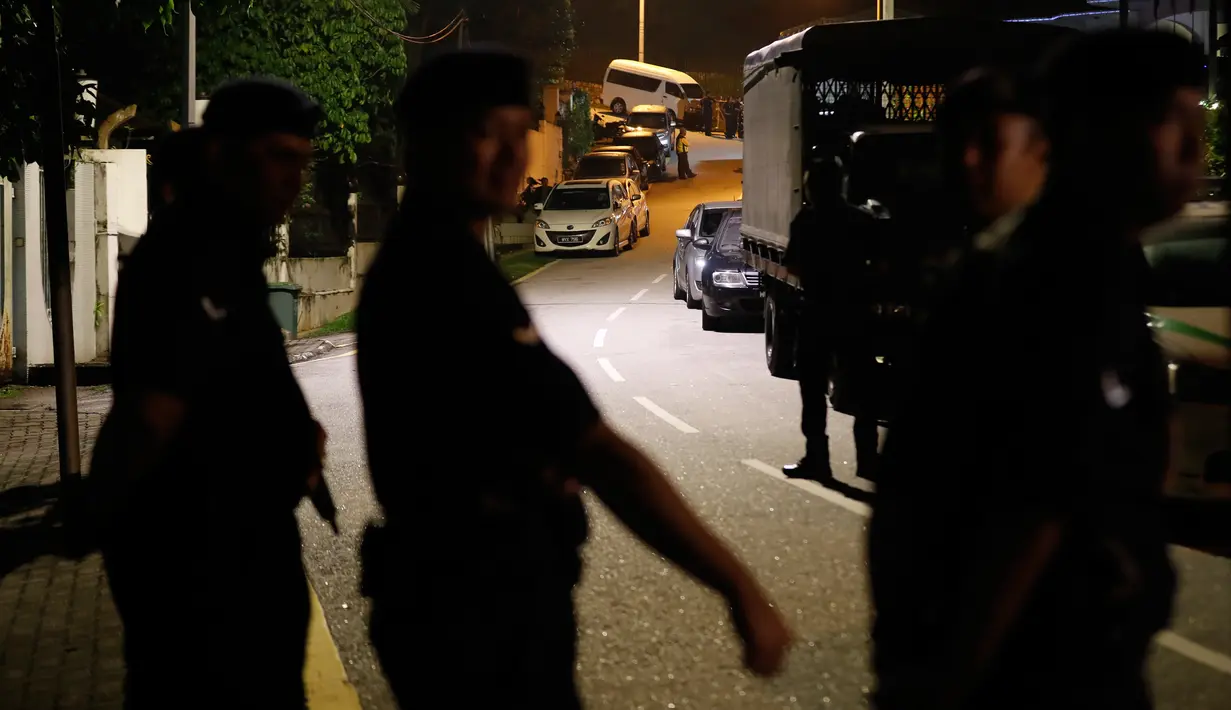Aparat kepolisian berjaga di depan rumah mantan Perdana Menteri Malaysia, Najib Razak di Kuala Lumpur, Rabu (16/5). Polisi melakukan penggeledahan di kediaman Najib usai Salat Tarawih untuk mencari bukti dan dokumen terkait kasus 1MDB. (AP/Vincent Thian)