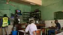 Pengunjung menonton televisi sebuah konferensi pers dari Pejabat Uni Afrika di sebuah restoran sambil menunggu hasil resmi pemilihan umum Kenya di Kisumu (10/8). Berdasar laporan, Uhuru Kenyatta masih unggul dari Raila Odinga. (AFP Photo/Jennifer Huxta)