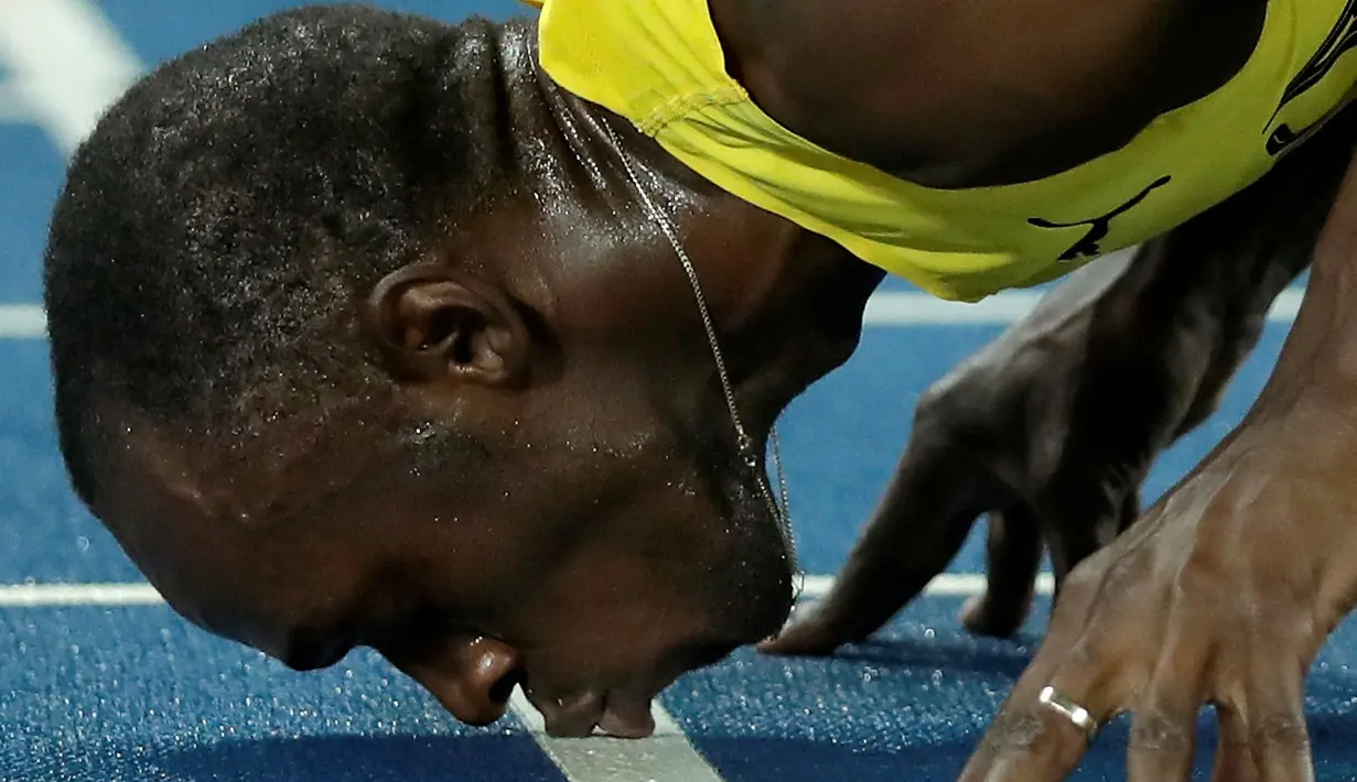 Sprinter Jamaika, Usain Bolt, mencium lintasan setelah meraih medali emas lari 200m putra Olimpiade Rio 2016 di Olympic Stadium, Rio de Janeiro, Brasil, (18/8/2016). (AP Photo/Matt Dunham)
