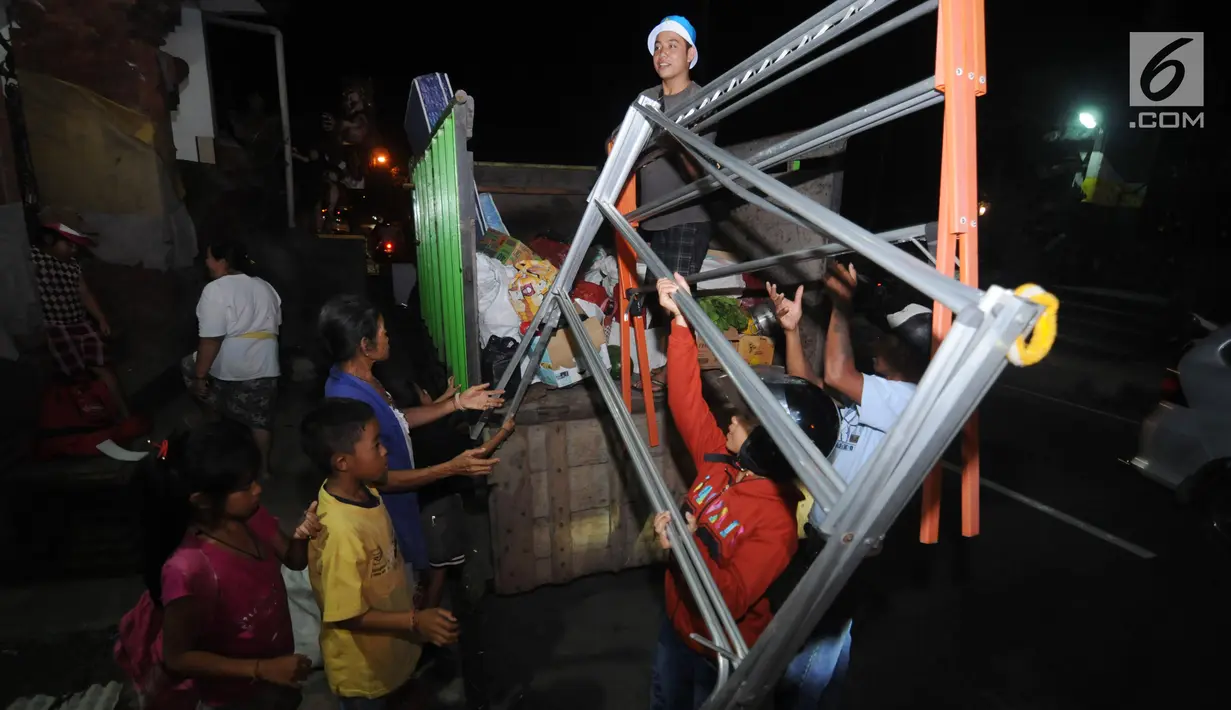 Warga memindahkan barang ke dalam truk di Desa Akah, Klungkung , Bali, Sabtu (30/9). Menurut Kepala Dinas BPBD Kelungkung I Putu Widyada warga pengungsi yang berasal dari Zona kuning melebihi yang di perkirakan. (Liputan6.com/Gempur M Surya)