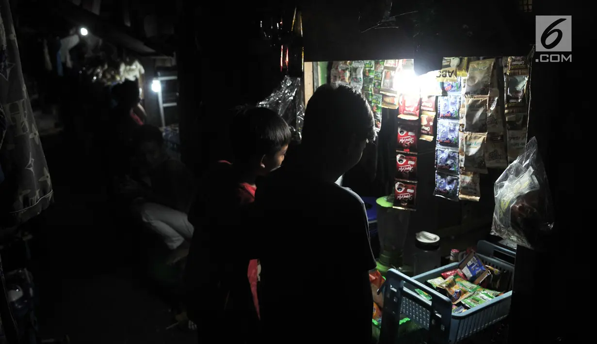 Anak-anak membeli minuman di salah satu warung yang berada di Gang Venus, Kelurahan Jembatan Besi, Kecamatan Tambora, Jakarta, Kamis (5/9/2019). Warga Gang Venus harus menggunakan listrik selama 24 jam penuh akibat minimnya cahaya matahari yang masuk ke kawasan mereka. (merdeka.com/Iqbal Nugroho)