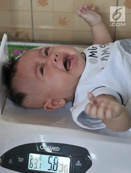 Bayi ditimbang saat menjalani pemeriksaan rutin di Posyandu Ria Balita, Cipinang, Jakarta, Selasa (16/7/2019). Presiden Joko Widodo akan menjamin kesehatan ibu hamil, bayi, balita, dan anak usia sekolah. (merdeka.com/Iqbal Nugroho)