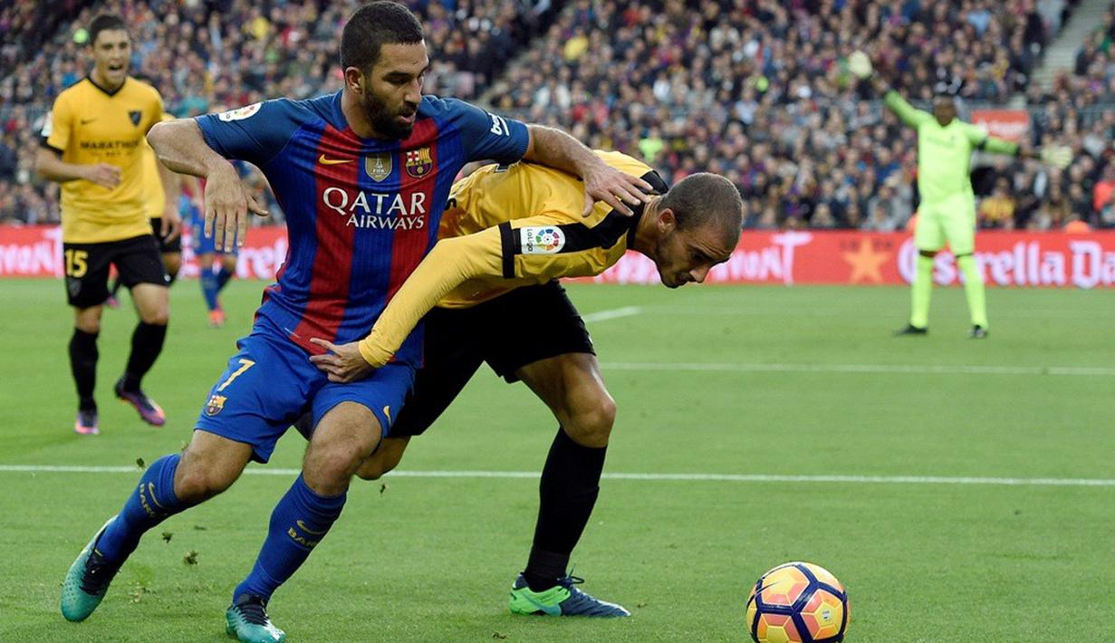 Penyerang Barcelona, Arda Turan, berusaha melewati bek Malaga, Mikel Villanueva, dalam lanjutan La Liga di Camp Nou, Barcelona, Sabtu (19/11/2016). (AFP/Lluis Gene)