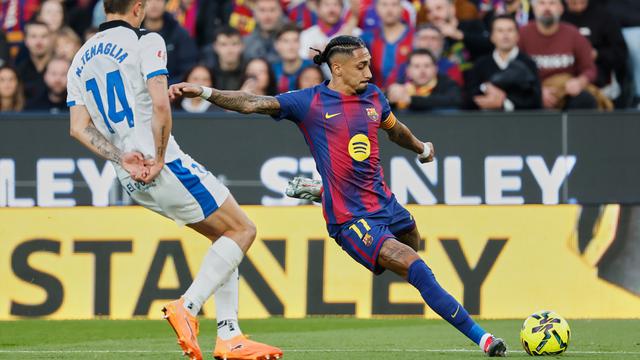 Raphinha dari Barcelona, kanan, menendang bola dengan diadang oleh Nahuel Tenaglia dari Alaves