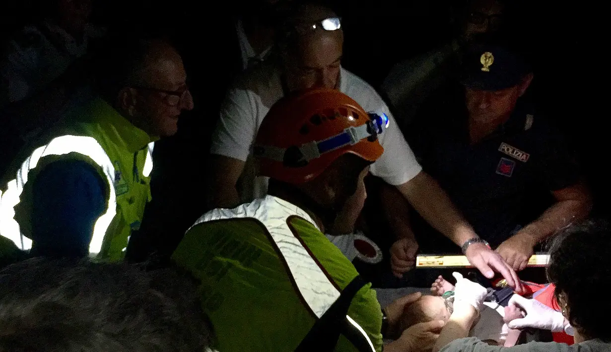 Petugas saat mengecek kondisi bayi gempa melanda pulau wisata di Ischia, di lepas pantai Napoli, Italia (21/8). Gempa berkekuatan 4.0 skala Richter (SR) membuat beberapa bangunan hancur. (AFP Photo/Mauro Pagnano)