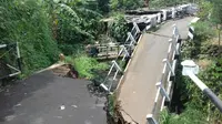 Puing jembatan beton yang terletak di Kampung Babakan Sukamantri RT 04/ Rw 07, Kelurahan Pasir Jaya ini dibiarkan teronggok melintang menutupi aliran kali. (Liputan6.com/Darno)