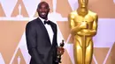 Kobe Bryant berpose sambil memegang Piala Oscar 2018 usai meraih penghargaan di Academy Awards ke-90 di Hollywood, California (3/4). Bryant berhasil merebut satu piala untuk kategori film animasi pendek terbaik. (AFP/Frederic J. Brown)