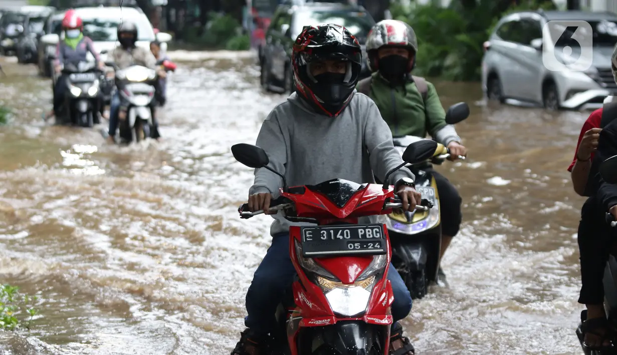 Pengendara sepeda motor menerobos sebagian Jalan Bungur Besar Raya yang tergenang air, Jakarta, Selasa (18/1/2022). Genangan air membuat arus lalu lintas di sekitar depan PN Jakarta Pusat menjadi terganggu dan tersendat. (Liputan6.com/Helmi Fithriansyah)