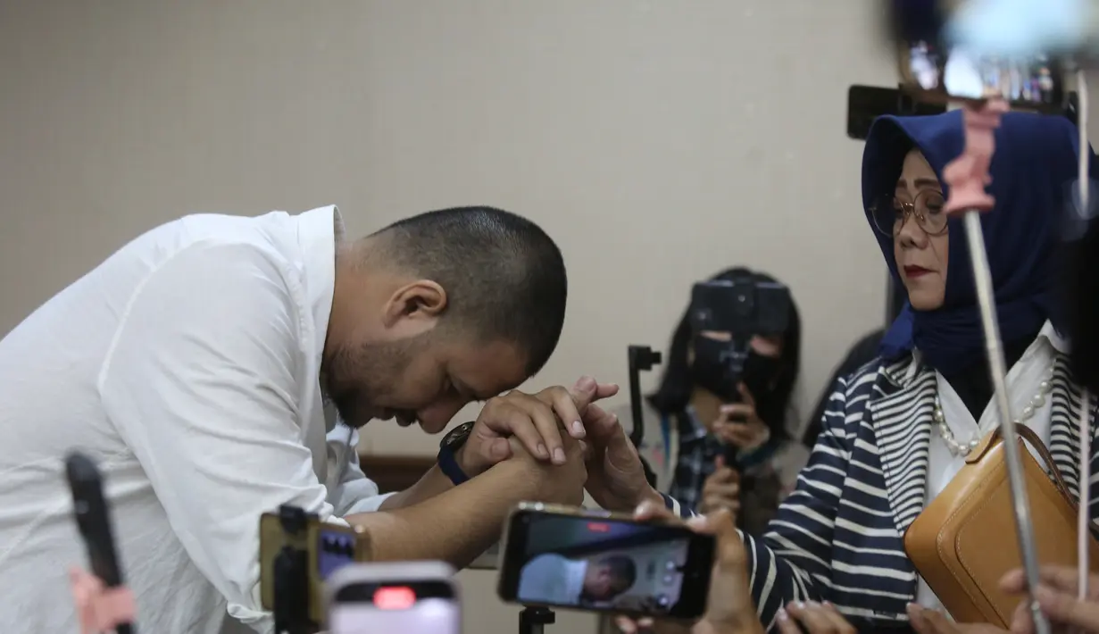 Ammar Zoni menjadi terdakwa karena diduga terlibat dalam peredaran narkotika di dalam Lapas Salemba, Jakarta. Tampak dalam foto, Pesohor Muhammad Ammar Akbar alias Ammar Zoni mencium tangan ibu angkatnya saat dihadirkan secara langsung pada persidangan terkait kasus peredaran narkotika di dalam Lembaga Pemasyarakatan (Lapas) Salemba di Pengadilan Negeri Jakarta Pusat, Kamis (18/12/2025). (merdeka.com/Arie Basuki)