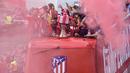 Para pemain Atletico Madrid menyapa suporter saat mengikuti konvoi perayaan gelar Liga Europa di Madrid, Jumat (18/5/2018). Kota Madrid menjadi merah saat perayaan gelar juara Atletico. (AFP/Oscar Del Pozo)