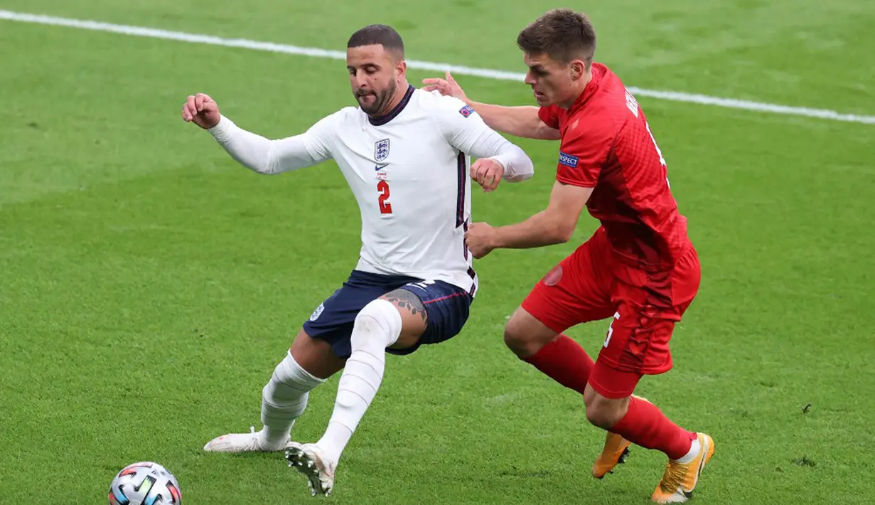 Pemain Denmark Joakim Maehle (kanan) berebut bola dengan pemain Inggris Kyle Walker pada pertandingan semi final Euro 2020 di Stadion Wembley, London, Inggris, 7 Juli 2021. Bek Denmark ini terbukti menjadi salah satu pilar yang sulit ditembus selama Euro 2020. (Catherine Ivill/POOL/AFP)