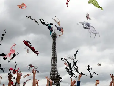 Puluhan wanita melemparkan bra mereka ke udara saat mengikuti acara tahunan "Pink Bra Toss" di depan Menara Eiffel, Paris, Minggu (13/5). Aksi yang diselenggarakan Pink Bazaar ini untuk meningkatkan kesadaran mengenai kanker payudara. (AP/Christophe Ena)