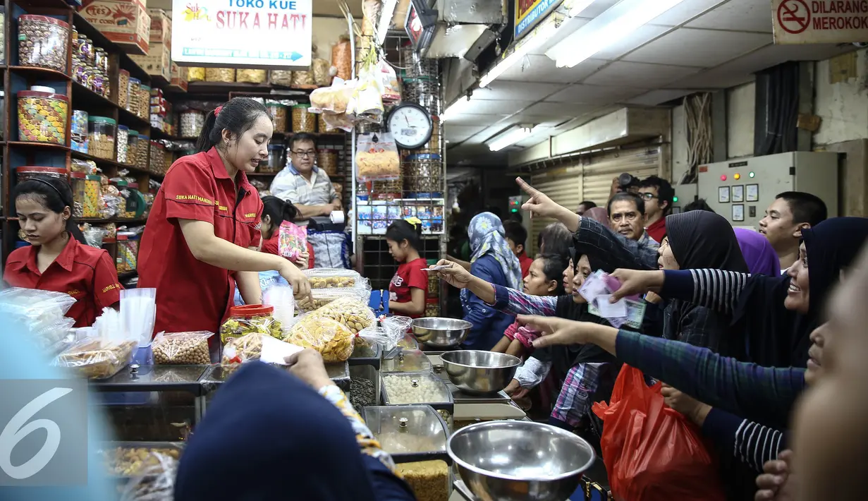 Sejumlah calon pembeli mengantre membeli kue kering di Pasar Jatinegara, Jakarta, Senin (27/6). Meskipun Hari Raya Idul Fitri atau Lebaran masih sepekan lagi, namun toko kue kering di Pasar Jatinegara mulai diserbu pembeli. (Liputan6.com/Faizal Fanani)