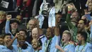 Kapten Manchester City, Vincent Kompany, mengangkat trofi Piala Liga usai mengalahkan Arsenal di Stadion Wembley, London, Minggu (25/2/2018). City menang 3-0 atas Arsenal. (AFP/Glyn Kirk)