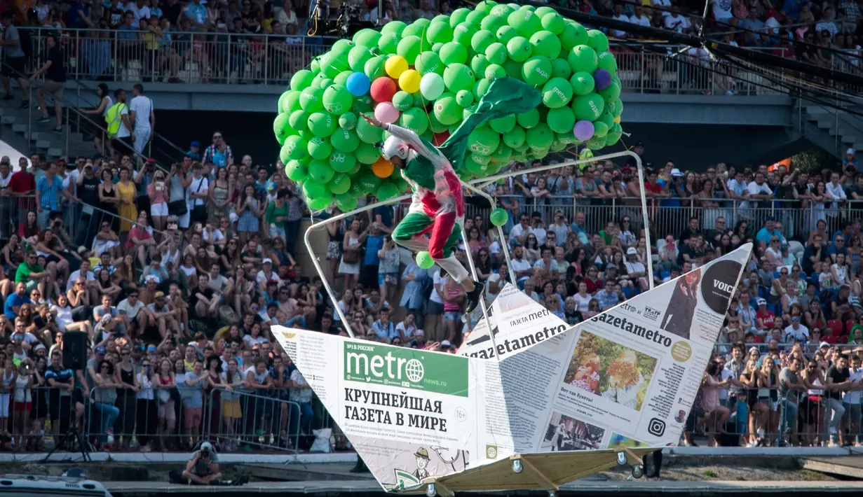 Peserta mengendarai pesawat mainan yang dihias dengan balon terjun bebas saat mengikuti Flugtag 2017 di Moskow, Rusia (13/8). Dalam aksinya, seluruh peserta lomba lepas landas dari sebuah kapal tongkang. (AFP Photo/Yuri Kadobnov)