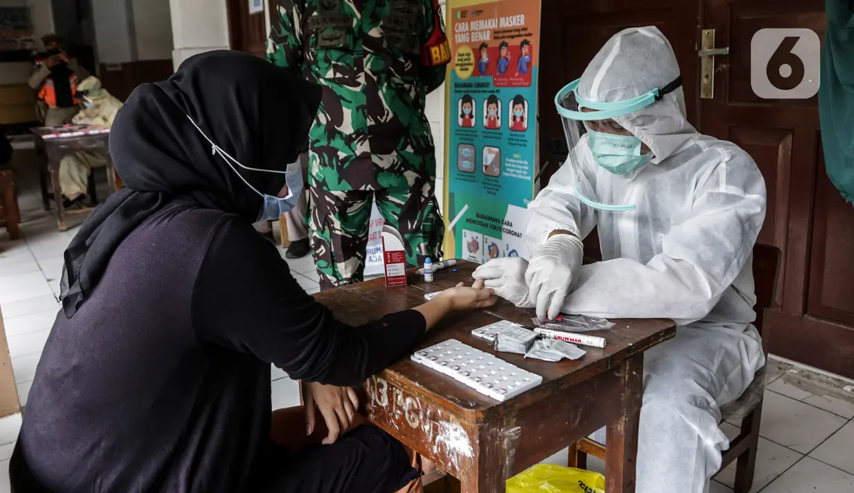 Warga melakukan tes cepat (rapid test) massal Covid-19 di SDN Petamburan 01, Petamburan, Jakakrta, Jumat (27/11/2020). Rapid test massal ini digelar sebagai langkah petugas dalam melakukan testing, dan tracing setelah adanya kerumunan di Petamburan. (Liputan6.com/Johan Tallo)
