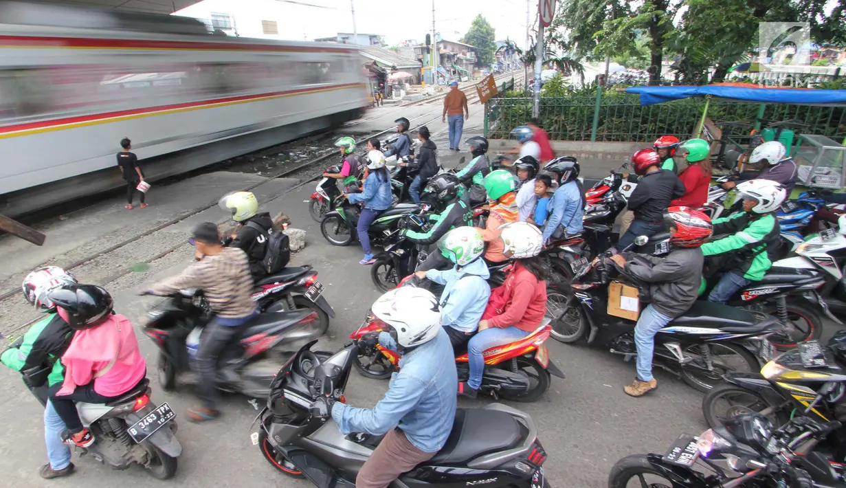 Kereta melintas di perlintasan kereta api yang tidak berpalang pintu di kawasan Roxy, Jakarta, Rabu (21/3). Pembukaan celah untuk akses sepeda motor di pintu perlintasan kereta api tersebut sangat membahayakan. (Liputan6.com/Arya Manggala)