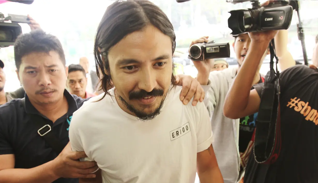 Marcello Tahitoe alias Ello dikawal polisi berpakaian preman masuk ke Rumah Sakit Ketergantungan Obat (RSKO) Cibubur, Jakarta , Senin (14/8). Ello akan menjalani assessment di RSKO Cibubur selama beberapa waktu ke depan. (Liputan6.com/Herman Zakharia)