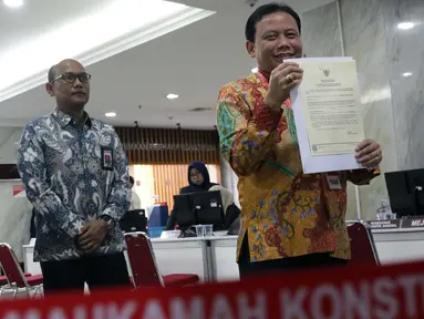 Ketua Bawaslu RI, Abhan menunjukkan Akta Pengajuan Keterangan usai menyerahkan alat bukti untuk menghadapi perselisihan hasil Pilpres 2019 di Mahkamah Konstitusi, Jakarta, Rabu (12/6/2019). Bawaslu menyerahkan 134 alat bukti serta keterangan setebal 151 halaman. (Liputan6.com/Helmi Fithriansyah)