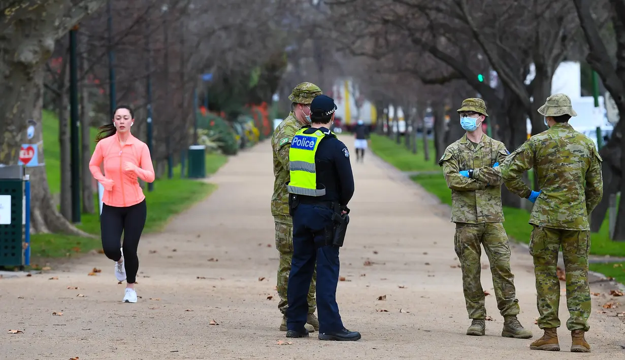 Petugas kepolisian dan tentara berpatroli di jalur lari yang populer di Melbourne, Selasa (4/8/2020). Melbourne memasuki pembatasan Tahap 4 dengan aturan yang lebih ketat sebagai upaya untuk membatasi pergerakan masyarakat dan penyebaran COVID-19. (William WEST / AFP)