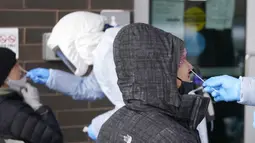 Warga menjalani tes COVID-19 di luar Departemen Kesehatan Salt Lake County, Salt Lake City, Utah, Amerika Serikat, 28 Desember 2021. Jumlah kasus COVID-19 di AS melonjak saat para pelancong banyak bepergian pada masa liburan Natal. (AP Photo/Rick Bowmer)