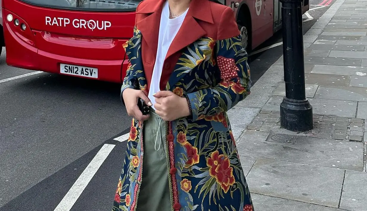 Istri Menko Yanti Airlangga tampil unik saat liburan mengenakan outer batik. Atasan kaus putih polos, dipadu dengan ce lana panjang bernuansa kehijauan, lalu ditumpuk mengenakan outer batik Cirebon bernuansa merah-biru dengan motif flora yang cantik. [Instagram/yanti.airlangga]