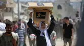 Seorang wanita Palestina membawa bantuan makanan ketika orang-orang kembali ke kamp pengungsi Nuseirat dari titik distribusi Yayasan Kemanusiaan Gaza yang didukung oleh Amerika Serikat (AS) di dekat koridor Netsarim, Jalur Gaza tengah, pada 27 Juli 2025. (Eyad BABA/AFP)