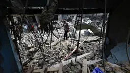 Warga Palestina yang mengungsi memeriksa kerusakan setelah sebuah rumah menjadi sasaran serangan Israel di kamp pengungsi Maghazi, Jalur Gaza Tengah pada Kamis 21 Mei 2026. (Eyad Baba/AFP)