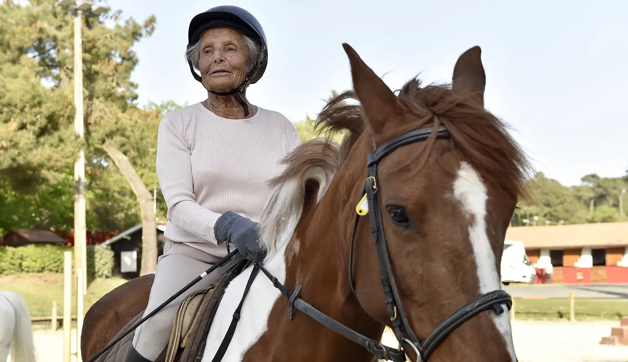 Nicole de Villeneuve (89) berada di atas kuda selama latihan stabil berkuda di Arcachon (24/4). Nicole kembali berkuda pada September tahun lalu dan mengaku tidak memiliki kekuatan fisik yang sama seperti sebelumnya. (AFP Photo/Georges Gobet)
