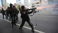 Petugas menembakan gas air mata ke arah demonstran di Caracas, Venezuela, (6/4). Bentrokan dipicu oleh keputusan kontroversial Mahkamah Agung untuk membubarkan parlemen Venezuela yang mayoritas kelompok oposisi. (AP Photo / Ariana Cubillos)