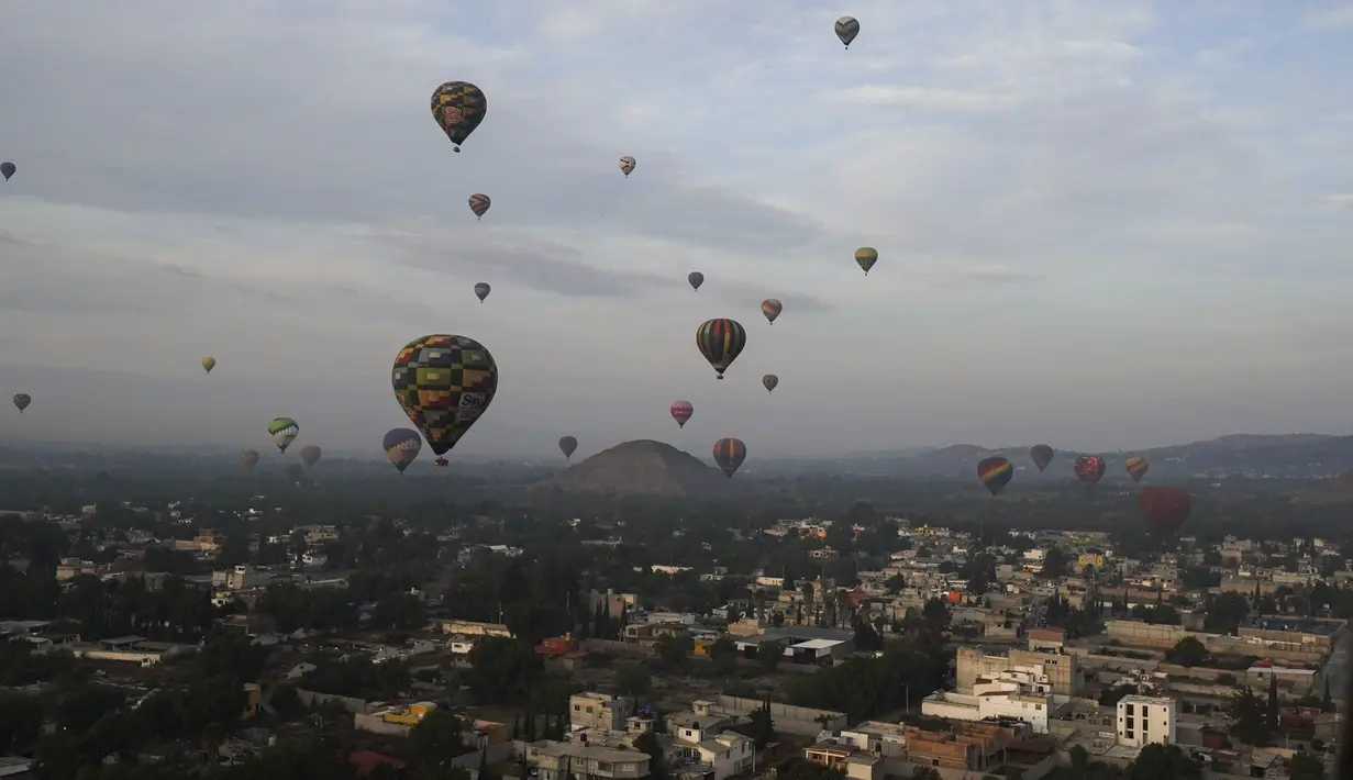 Balon udara yang dipenuhi turis terbang di atas situs arkeologi Teotihuacan, tepat di utara Mexico City, Minggu, 24 Desember 2023. (AP Photo/Marco Ugarte)
