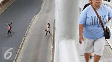 Pejalan kaki menyeberang di bawah Jembatan Penyeberangan Orang (JPO) di Jakarta, Kamis (19/11). Selain membahayakan keselamatan, perilaku buruk pejalan kaki tersebut juga menjadi salah satu penyebab kemacetan di Ibu Kota. (Liputan6.com/Immanuel Antonius)