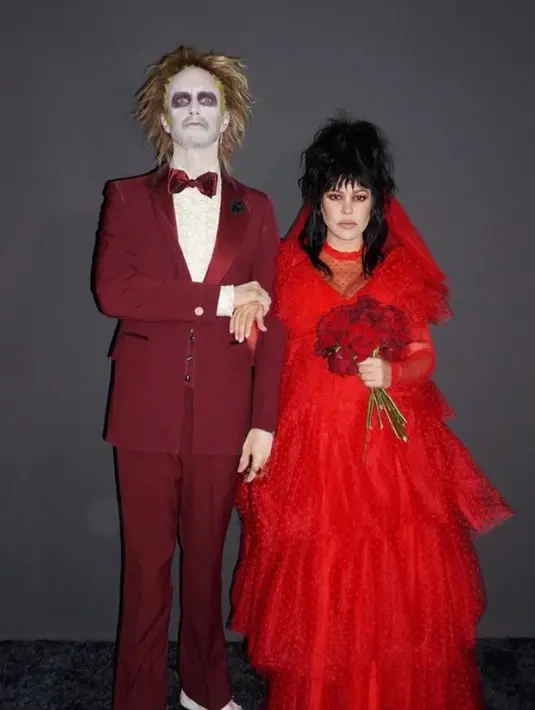Untuk Halloween tahun ini, Kourtney Kardashian Barker dan Travis Barker berdandan seperti karakter Michael Keaton dan Winona Ryder dalam film klasik "Beetlejuice" tahun 1988. Kourtney tampil dengan gaun merah pengantin yang ikonik. [@kourtneykardash]
