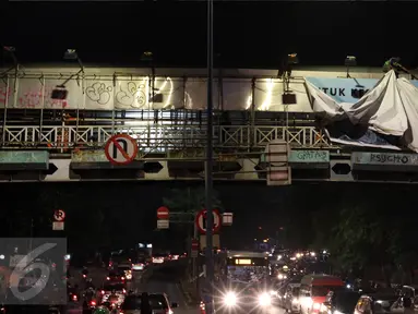 Petugas gabungan membongkar papan reklame di jembatan penyeberangan orang (JPO) di Jalan Warung Buncit Raya, Jakarta, Jumat (7/10).  Adapun reklame itu dibongkar karena tidak berizin atau tidak sesuai syarat teknis reklame. (Liputan6.com/Helmi Afandi)